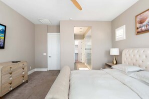 Une chambre à coucher avec un lit, une commode et un tableau accroché au mur.