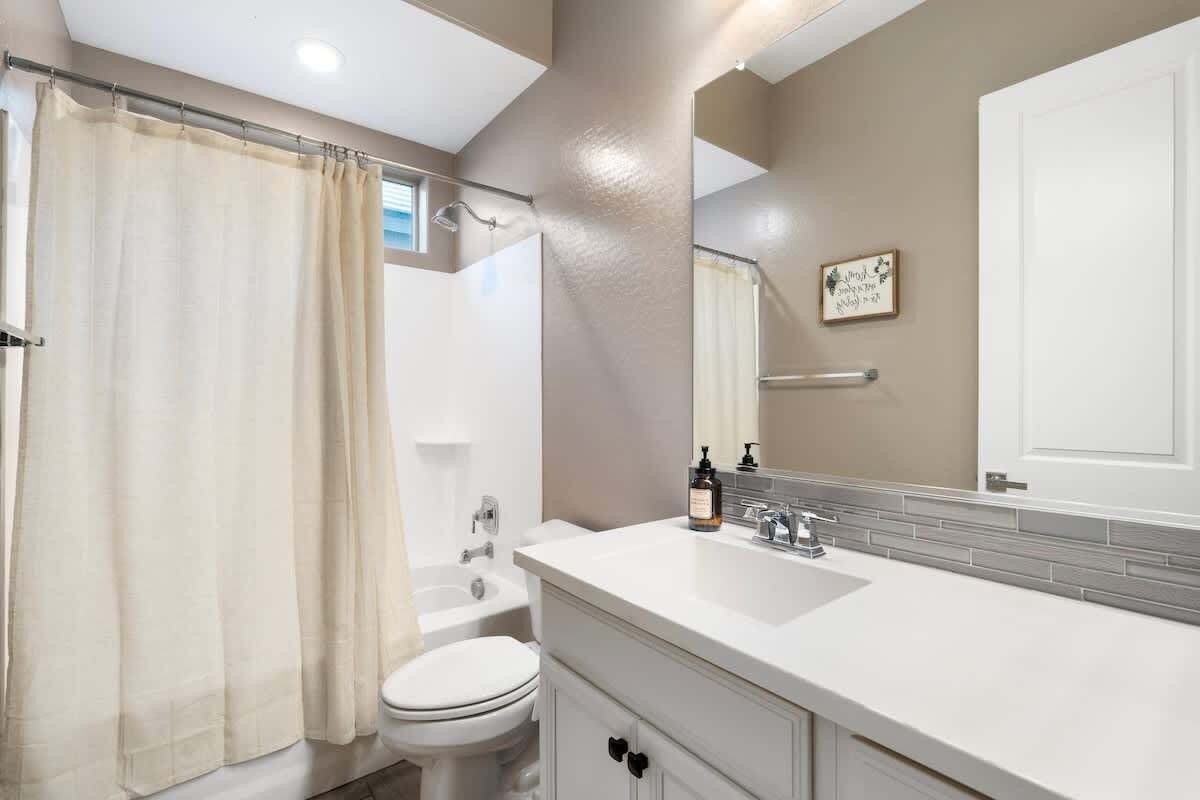 Een badkamer met douche, toilet en wastafel.