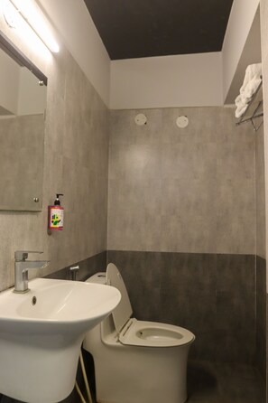Une salle de bain avec un lavabo, des toilettes et un miroir.