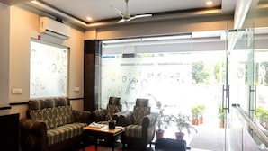 A modern lobby with a sectional sofa, a coffee table, and potted plants. - Destino by Halcyon Hitec City (Hyderabad)