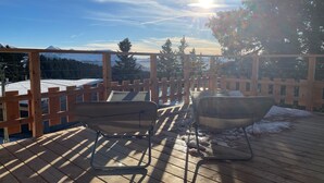A wooden deck with a metal chair and a metal tub, overlooking a snowy mountain range. - Chalet Chamrousse 1750, 7 Pers, 3 ch, Terrasse, vue Magnifique sur le Vercors (Chamrousse)