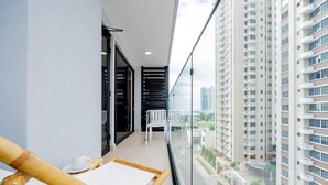 A balcony with a view of high-rise buildings, a white table with a cup, and a chair. - w* | Charming 1BR in San Francisco w/ View (Panamá)