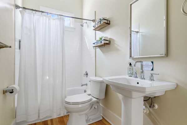 A bathroom with a toilet, sink, and shower curtain.