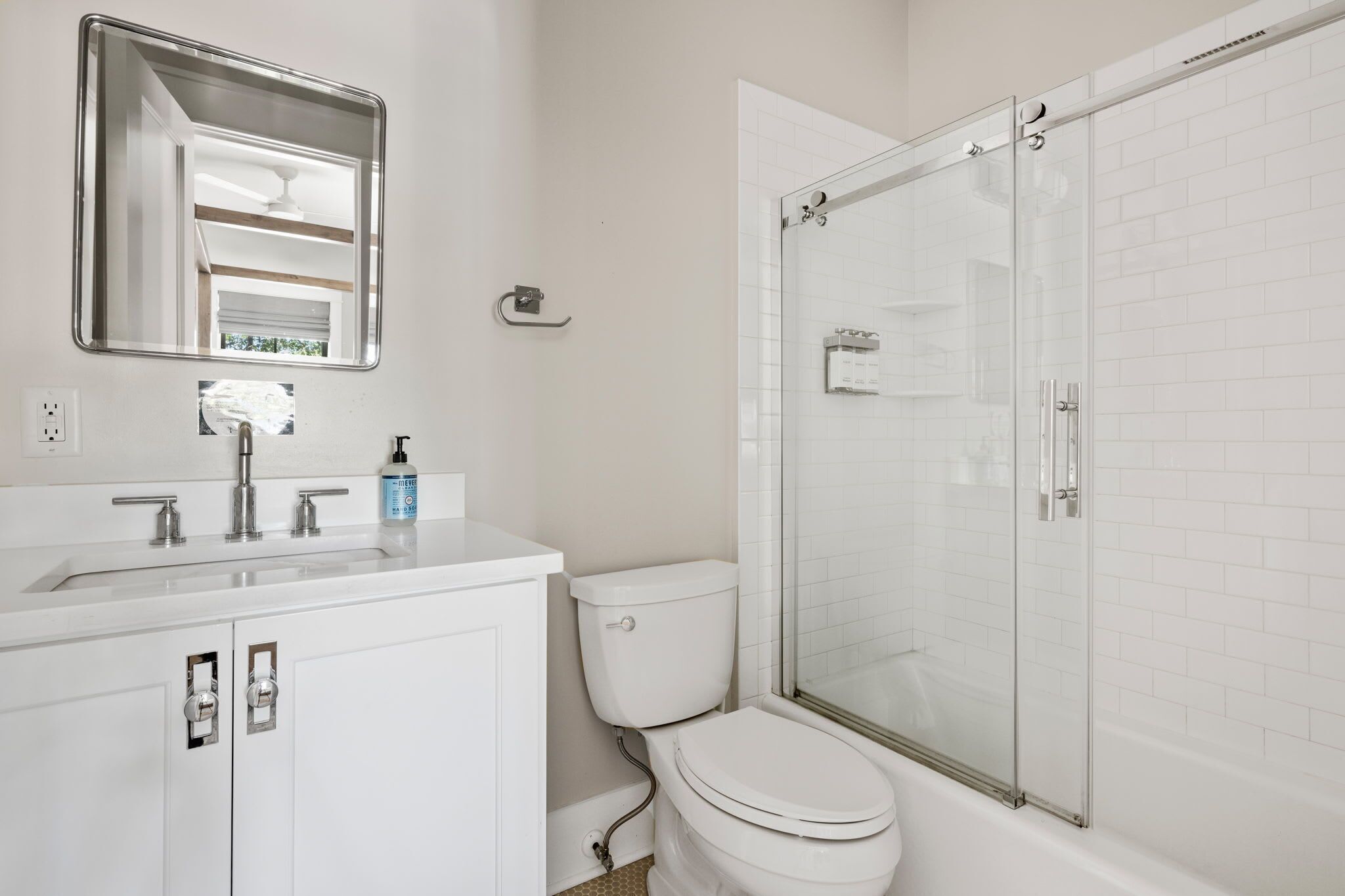 A bathroom with a white sink, a toilet, and a glass-enclosed shower.
