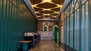 A modern hotel lobby with a long reception desk, seating area, and a geometric ceiling design. - Mihman Tuzla (Tuzla)