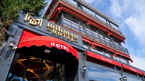 A hotel with a red awning and a balcony with red railings. - Mihman Tuzla (Tuzla)