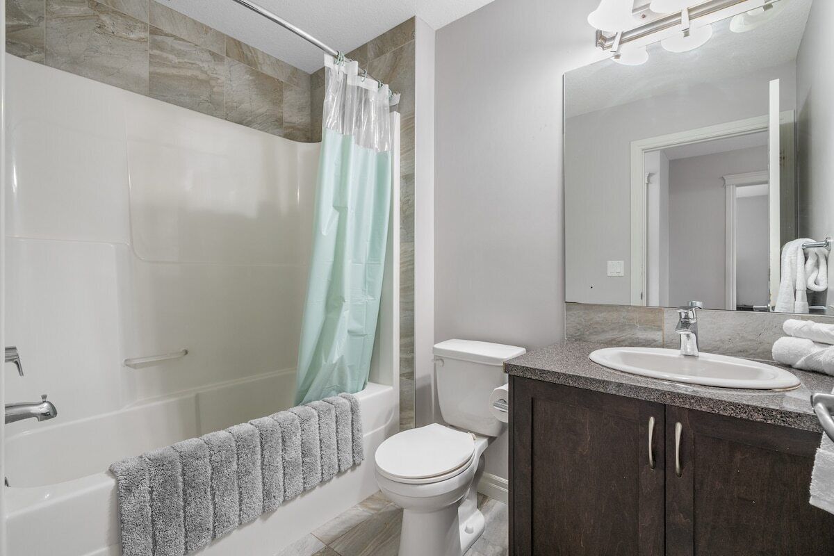 A modern bathroom with a bathtub, toilet, and sink.