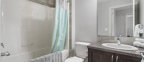 A modern bathroom with a bathtub, toilet, and sink.