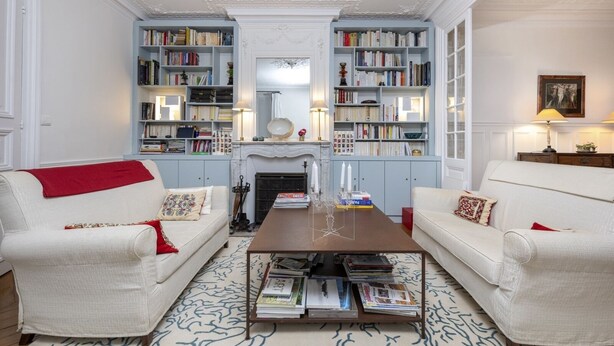 A traditional living room with two white sofas, a central coffee table, and bookshelves on either side. - Mindful Enlightenment, by Veeve (Paris)
