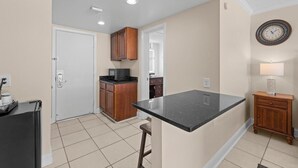 A kitchen with a microwave, cabinets, and a countertop. - Hidden Treasures, 1st Floor, Pool View King Room (Pawleys Island)