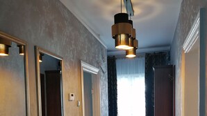 A hallway with wooden flooring, a ceiling light fixture, and a door at the end. - Apartament Konopnicka (Swinoujscie)
