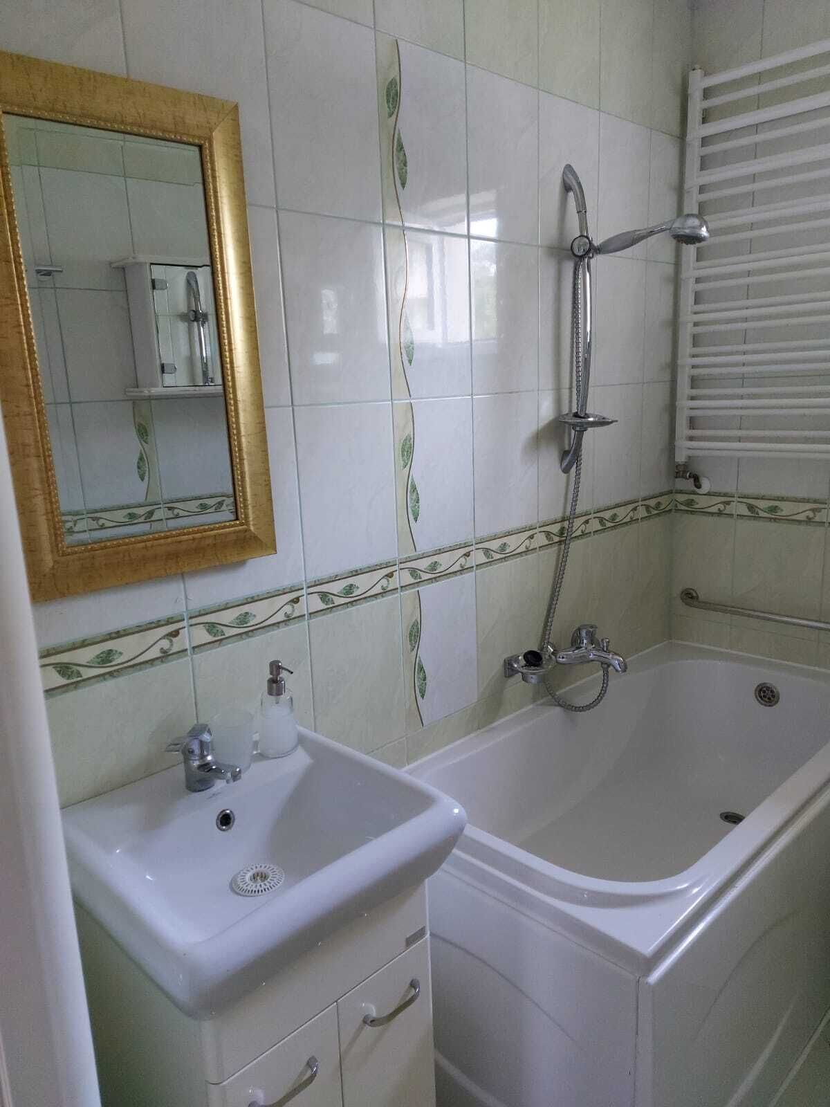 Ein Badezimmer mit Waschbecken, Spiegel und Badewanne.