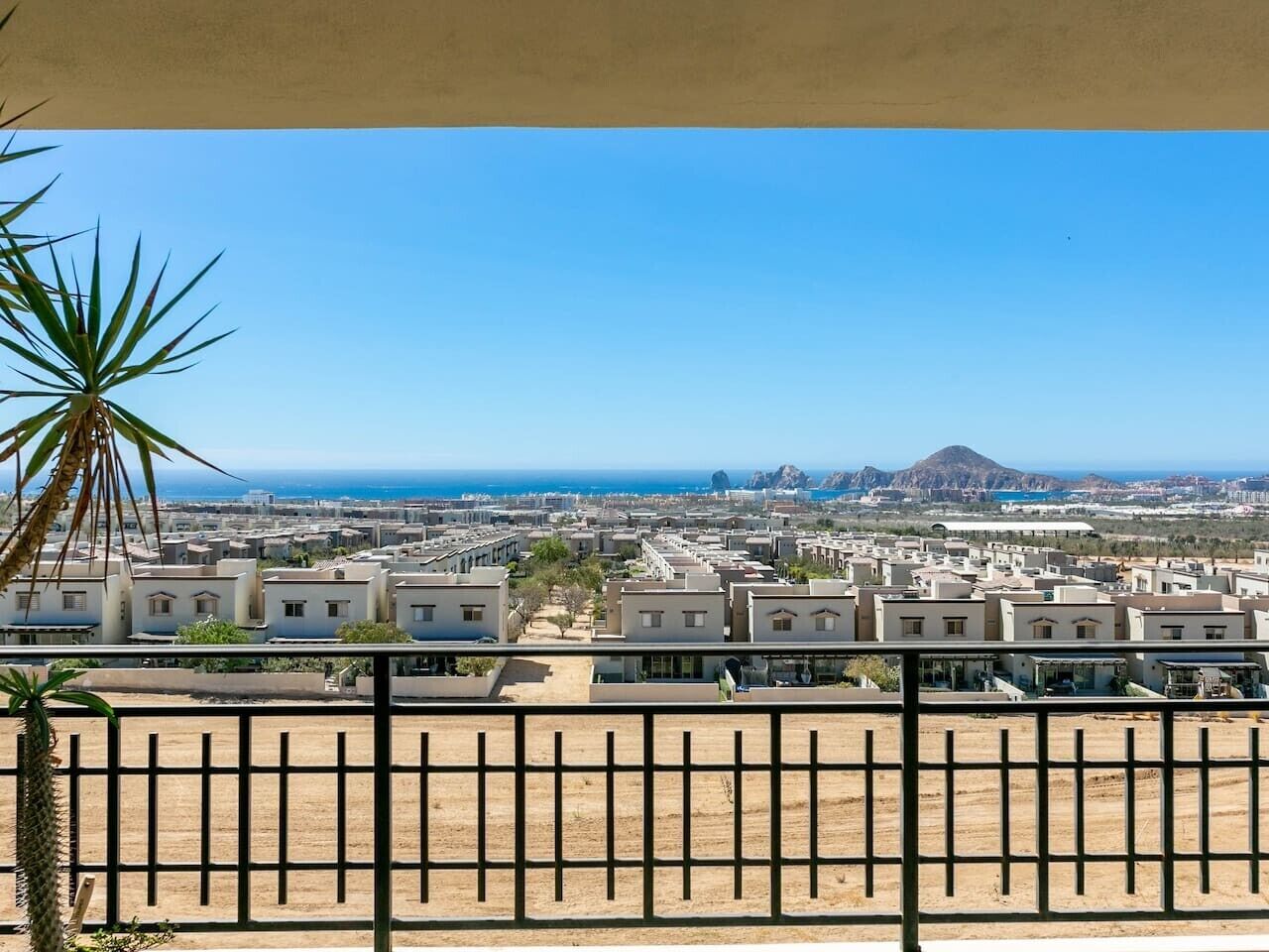 A residential area with multiple buildings, a clear sky, and a distant mountain.