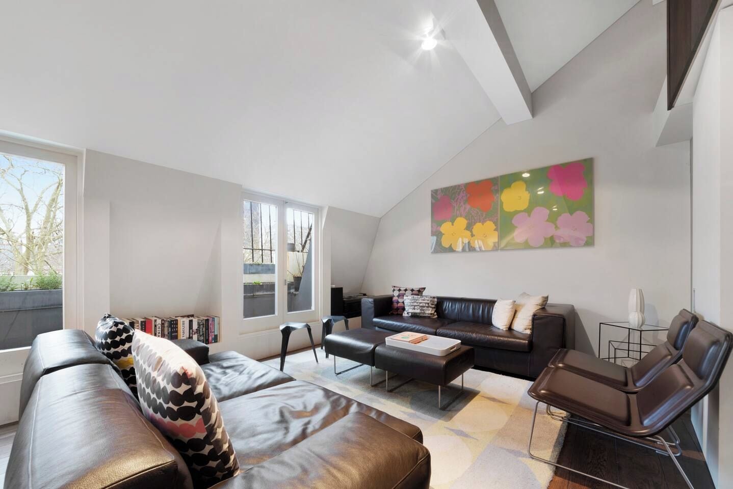 A modern living room with a sofa, coffee table, and a bookshelf.