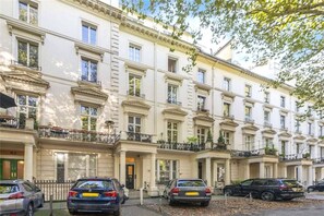 A multi-story building with a classic architectural style, featuring balconies with railings, a series of windows, and a gated entrance. - Westbourne Ter W2, Paddington, Elegant Design (London)