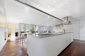 A modern kitchen with a central island, white cabinetry, and a large window providing natural light. - Westbourne Ter W2, Paddington, Elegant Design (London)
