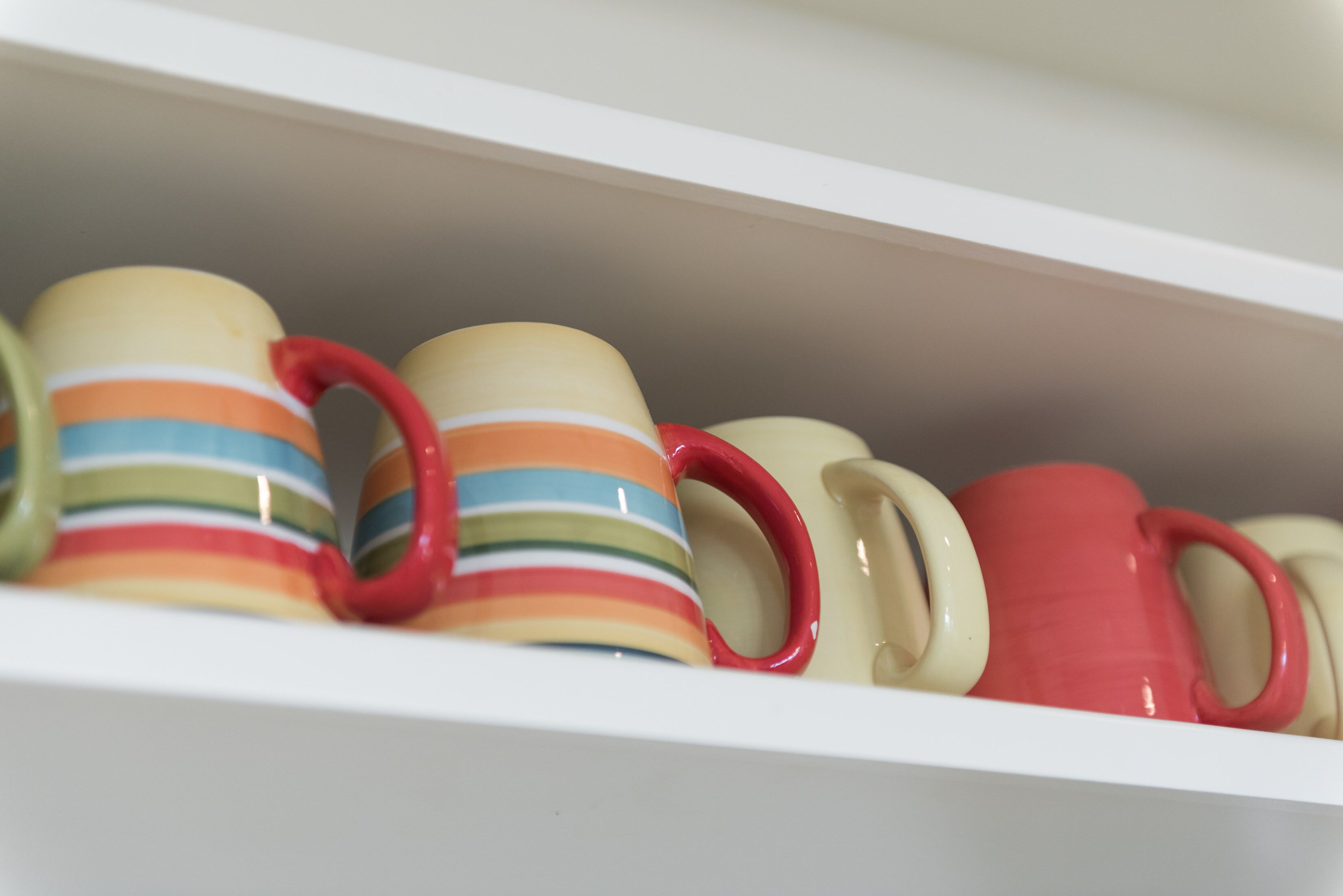 A shelf with various mugs.