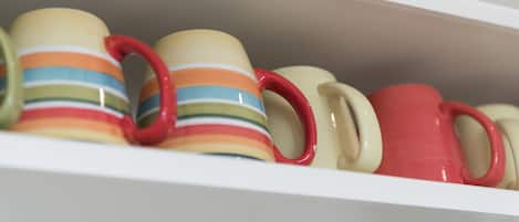A shelf with various mugs.