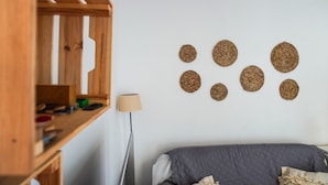 Ein Schlafzimmer mit einem Bett, einem Holzschrank und wandbündig angebrachten Webdekorationen.