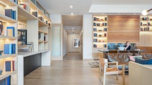 Een moderne woonkamer met een zithoek, een boekenkast en een eethoek.
