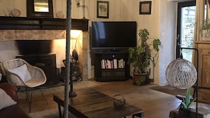 Una sala de estar acogedora con chimenea, televisión y asientos cómodos.