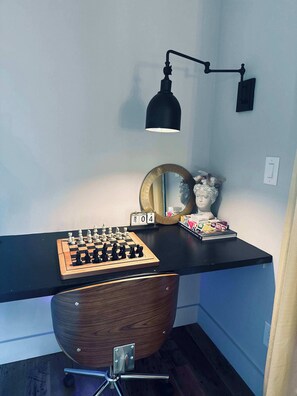 A desk with a chessboard, a lamp, a mirror, and a bust. - Tiny Space, Tons of Fun (Charlotte)