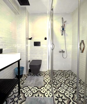 Ein Badezimmer mit Dusche, Toilette und Waschbecken.
