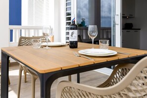A dining table with a bottle of wine, glasses, and cutlery. - Kavel 17 - Turtles Place with a refreshing shared pool in the heart of Kralendijk (Kralendijk)