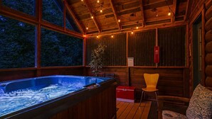 Un jacuzzi en una cabaña de madera con vistas a árboles.