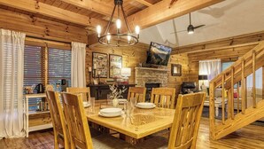 Un interior de madera con una mesa de comedor preparada para cuatro personas, rodeada de sillas de madera.