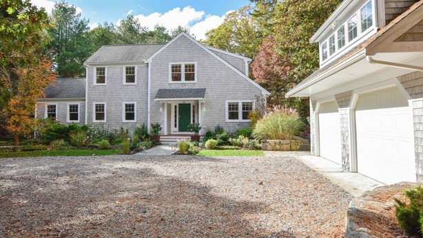 A two-story house with a front porch, a driveway, and a garage. - Perfectly private location w/deeded beach access! (Orleans)