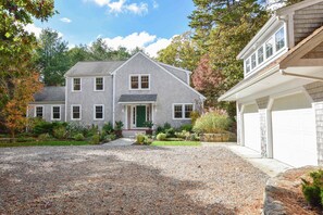 A two-story house with a front porch, a driveway, and a garage.