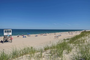 A beach with a lifeguard tower, sandy beach, and ocean. - Perfectly private location w/deeded beach access! (Orleans)