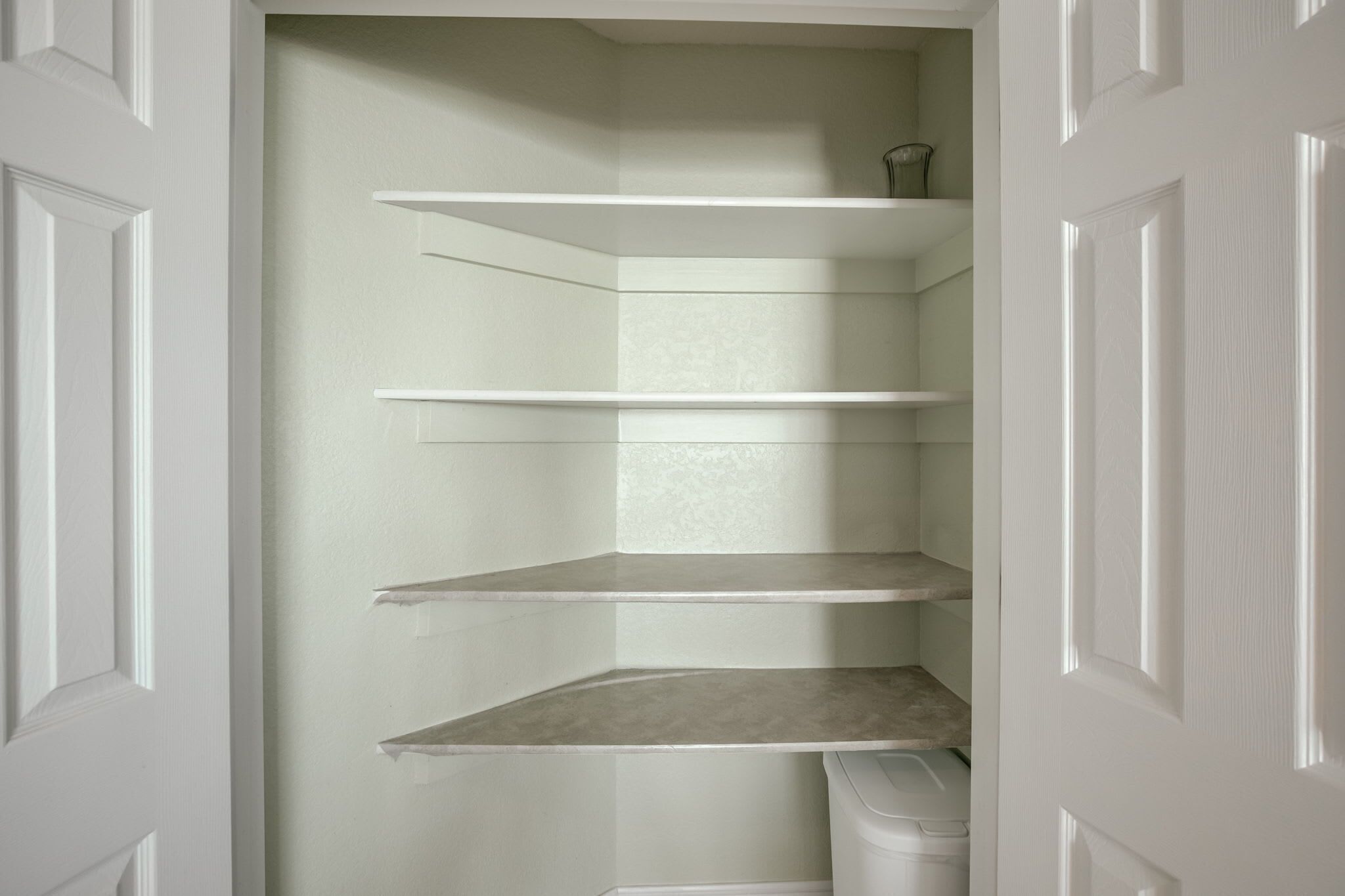 A white door with a built-in shelving unit with three shelves.