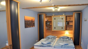 Une chambre à coucher comprenant un lit, une table de chevet, une bibliothèque et un miroir fixé au mur.