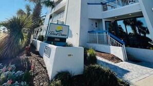 Un moderno e alto edificio di un hotel con un cartello che riporta "Forest Dunes" e l'indirizzo "5511".