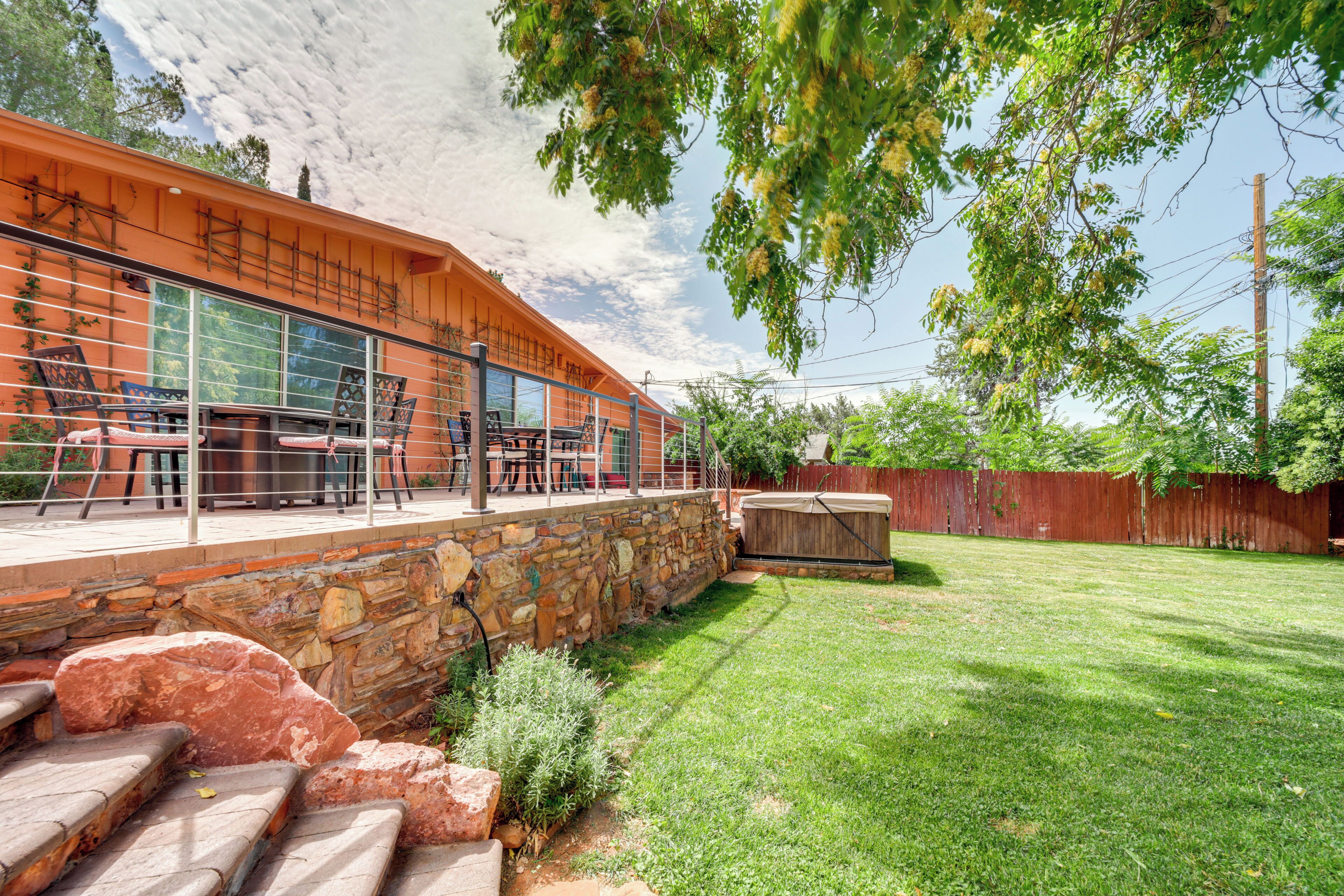 A patio area with outdoor furniture, a stone wall, and a wooden deck.
