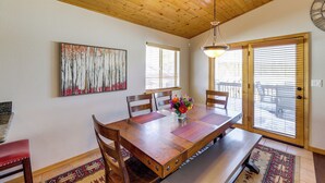 A dining room with a wooden table, chairs, and a vase of flowers. - Angel Fire Townhome w/ Hot Tub: 2 Mi to Ski Resort (Angel Fire)