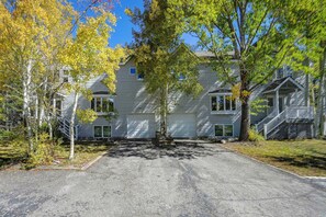 A two-story building with a gravel driveway leading to a garage. - Spacious Townhome Near Main St & Lake Dillon! (Frisco)