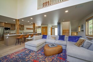 A modern living room with a sectional sofa, a coffee table, and a patterned rug. - Spacious Townhome Near Main St & Lake Dillon! (Frisco)