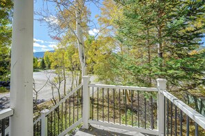 A view from a porch with a railing, overlooking a road and trees with autumn foliage. - Spacious Townhome Near Main St & Lake Dillon! (Frisco)