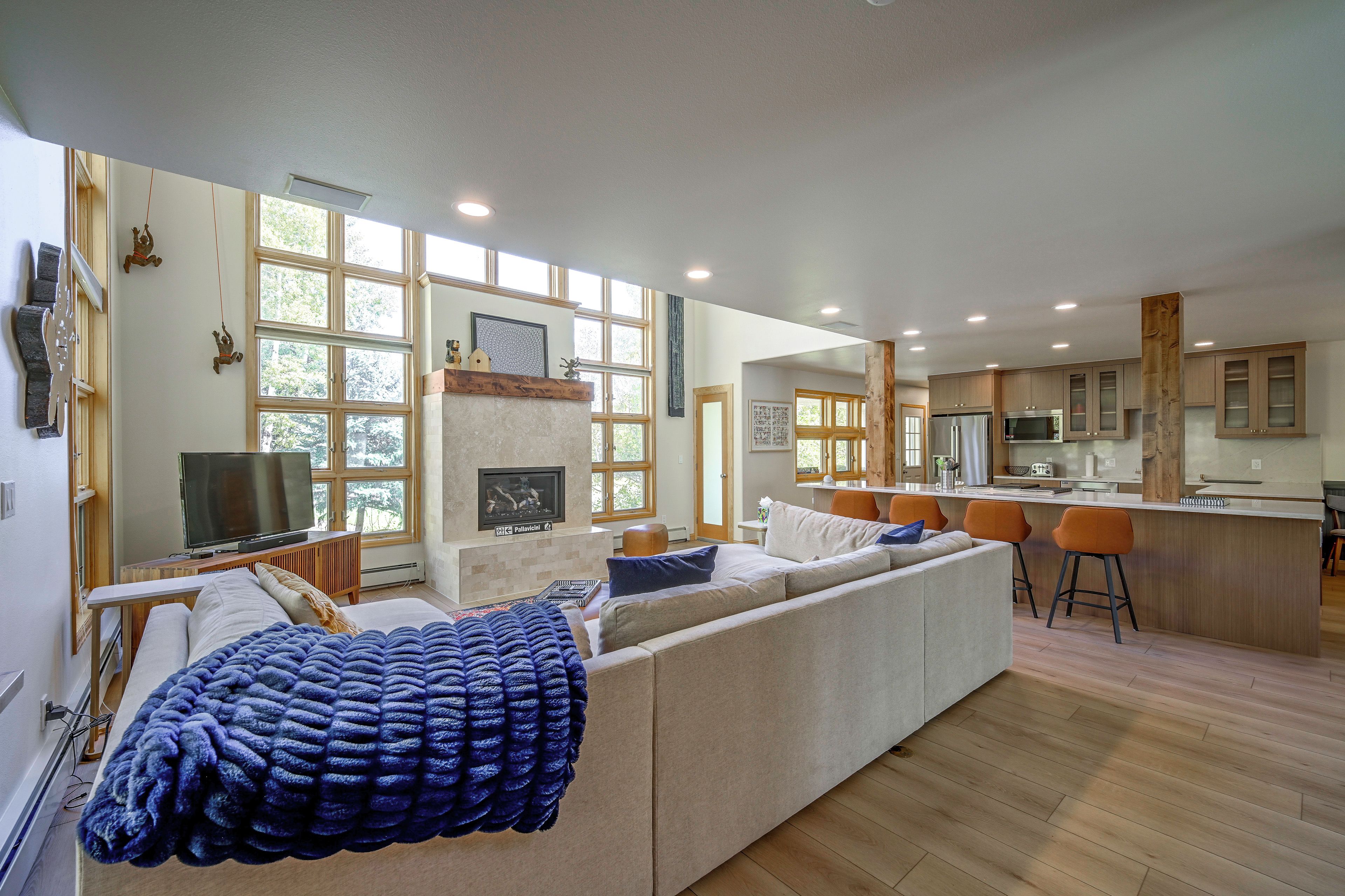A modern living room with a fireplace, a television, and a large window.
