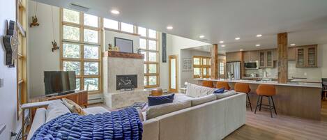 A modern living room with a fireplace, a television, and a large window.