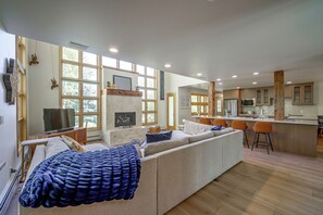 A modern living room with a fireplace, a television, and a large window. - Spacious Townhome Near Main St & Lake Dillon! (Frisco)