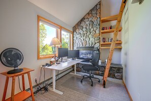 A home office with a desk, computer, and a stone wall. - Spacious Townhome Near Main St & Lake Dillon! (Frisco)