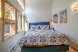 A bedroom with a large bed, a window with blinds, and wall-mounted artwork. - Spacious Townhome Near Main St & Lake Dillon! (Frisco)