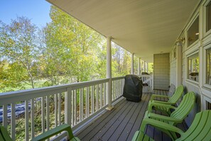 A covered porch with a railing, green chairs, and a grill. - Spacious Townhome Near Main St & Lake Dillon! (Frisco)
