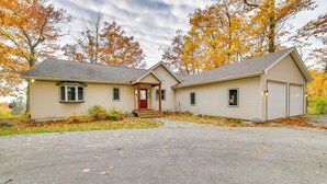 A two-story house with a front porch, garage, and a driveway. - 17 Mi to Skiing! Lake-view Michigan Home w/ Deck (Harbor Springs)