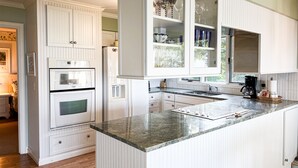 A kitchen with white cabinetry, a granite countertop, and a built-in oven. - Sunset Landing - Private Sandy Beach, Lamkin Drive 3 BD, 2 BATH (Sleeps 6) (Harbor Springs)