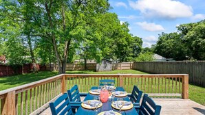 A wooden deck with a dining table set for six, surrounded by blue chairs. - TN Legends Retreat 3Bd/2Ba (Murfreesboro)
